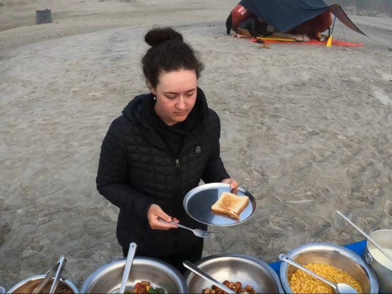 Woman holding a plate of food at camp